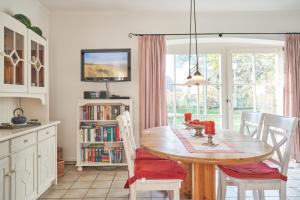 a dining room with a table and chairs and a window at Apfelgarten - a57043 in Boldixum