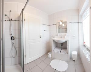 bagno bianco con doccia e lavandino di Wohnung 3 a Fehmarn