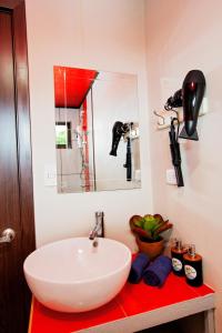 a bathroom with a white sink and a mirror at Casa Suculenta ,Monteverde con Jacuzzi Privado y Lavandería in Monteverde Costa Rica +20 photos