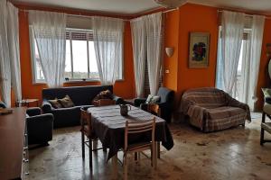 - un salon avec des murs orange, une table et un canapé dans l'établissement La villa di Flora singola MONTEROSSO ETNEO, à Fleri