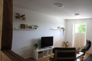 sala de estar con TV en una pared blanca en Turmfalke en Bad Sülze