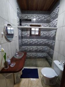 uma casa de banho com um lavatório e um WC em Rancho dos Mantas em Santo Antônio do Pinhal