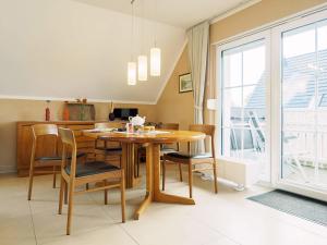 a dining room with a wooden table and chairs at Am Paalen 2 Whg 2 in Zingst