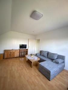 ein Wohnzimmer mit einem Sofa und einem Tisch in der Unterkunft Haus Aaliyah in Helmstedt