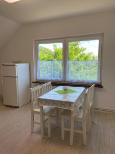 ein Esszimmer mit einem Tisch und Stühlen sowie einem Kühlschrank in der Unterkunft Haus Aaliyah in Helmstedt