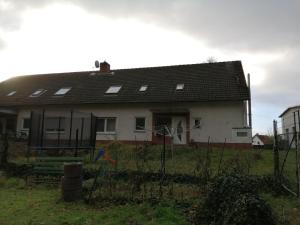 ein weißes Haus mit einem Zaun davor in der Unterkunft Haus Aaliyah in Helmstedt