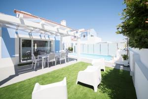 d'une terrasse privée avec des meubles blancs et une piscine. dans l'établissement Casa Lusitana da Praia & Casa Lusitana Mare Alta, à Porto Covo