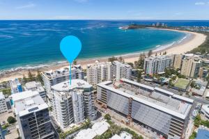 a large blue and white building next to a body of water at Cilento Mooloolaba in Mooloolaba