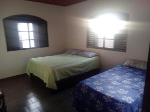 ピレノポリスにあるCasa 57 Temporadaのベッドが2つと窓が2つある寝室