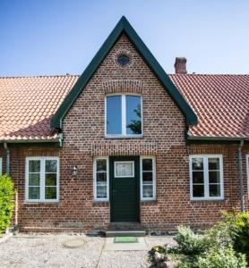 a brick house with a green door at Bellevue mitte in Schashagen