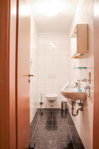 メッペンにあるFamilienhof Brüning - Gartenblickの白いバスルーム(洗面台、トイレ付)
