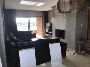 uma sala de estar com um sofá e uma mesa em Luxury apartment Prestigia em Marrakech