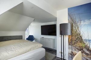 a bedroom with a bed and a flat screen tv at Altes Wasserwerk, App 4 in Zingst