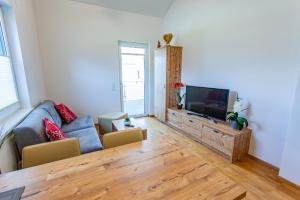sala de estar con sofá azul y TV de pantalla plana en Happy Aich 3 by Alpenidyll Apartments, en Aich