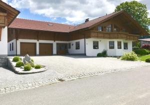 uma casa com uma grande entrada de garagem em frente em Ferienwohnung "Familienglück" em Achslach