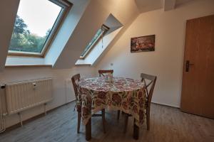 a dining room with a table and chairs and windows at Ferienwohnung im Pfarrhaus Kölzow in Kölzow