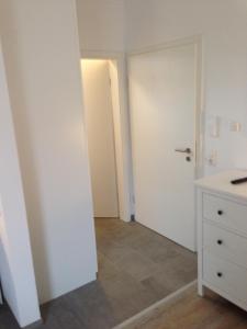 ein leeres Zimmer mit einem weißen Schrank und einer Tür in der Unterkunft Ferienwohnung bei Wessels in Schloß Holte-Stukenbrock
