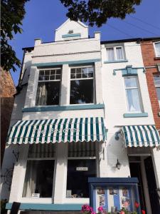 a white building with a green and white awning at The Beaches in Scarborough