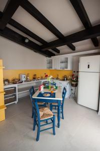una cucina con tavolo e sedie blu e frigorifero bianco di B&B I Fiori del Mare ad Agropoli