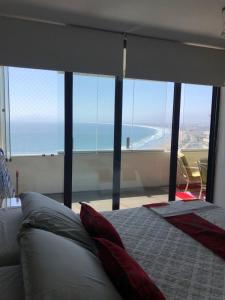 a bedroom with a bed and a view of the ocean at Departamentos Jardin del Mar IV Region, Chile in Coquimbo