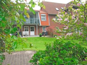 a house with a green yard with pink flowers at "Landhaus Voss" Typ 1 Nr3 in Staberdorf