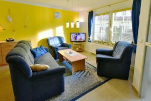 a living room with two couches and a tv at Am Deich 41 in Zingst