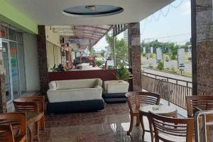 a balcony with a couch and a table and chairs at RedDoorz near Bandara Adi Soemarmo Solo in Tjolomadu