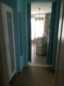 an open door to a living room with blue walls at Ferienwohnung Schmetterling II in Großenbrode