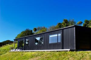 a black house on top of a hill at The Beach House on the Hill in Raglan