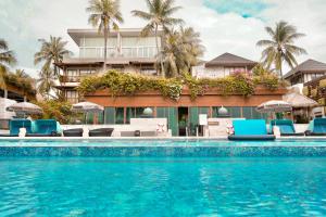 a swimming pool in front of a hotel at Dhevan Dara Beach Villa Kuiburi in Kui Buri