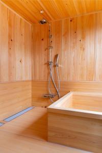 eine Sauna mit einer Dusche in einer Holzwand in der Unterkunft eph TAKAYAMA in Takayama
