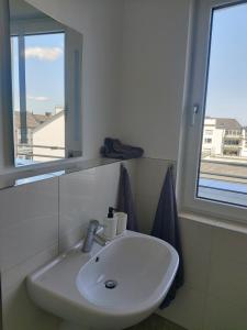 um lavatório branco numa casa de banho com uma janela em Casa Kronengarten Nr 16 em Hilden