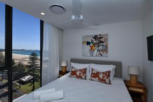 a bedroom with a bed and a large window at X Kirra Apartments in Gold Coast +167 photos