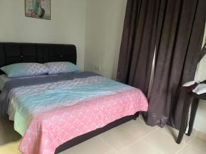 una camera con un letto e un piumone rosa e blu di Homestay Kedawang Langkawi a Pantai Cenang