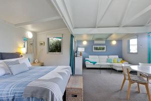a bedroom with a bed and a living room at The Bay Beach Studio ~ Ocean View in Apollo Bay