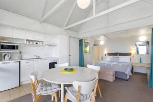 a kitchen and living room with a table and a bed at The Bay Beach Studio ~ Ocean View in Apollo Bay