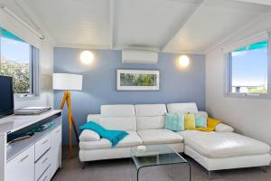 a living room with a white couch and a table at The Bay Beach Studio ~ Ocean View in Apollo Bay