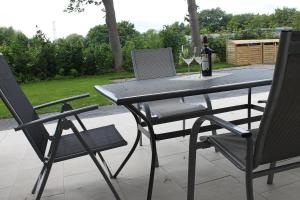 een tafel met twee stoelen en een glas wijn bij L2 - Ferienanlage Lindenstraße 1 - FERIENDOMIZIL HOLLICH in Grömitz