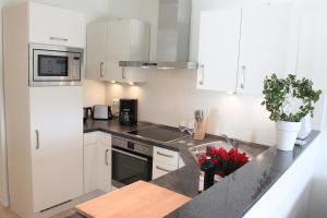 a kitchen with white cabinets and a counter top at L2 - Ferienanlage Lindenstraße 1 - FERIENDOMIZIL HOLLICH in Grömitz