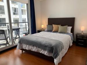 1 dormitorio con 1 cama grande y balcón en Super Ubicado y Hermoso Apartaestudio, en Tunja