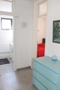 a bedroom with a blue dresser and a red bed at "Das Sonnendeck" - mit 2 Schlafzimmern, ruhig und strandnah gelegen in Grömitz
