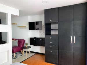 sala de estar con armario negro y TV en Super Ubicado y Hermoso Apartaestudio, en Tunja