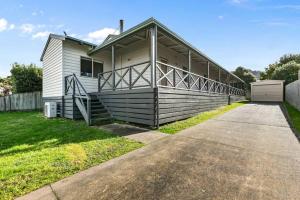 a house with a large porch on the side of it at The Landcastle ~Family Holiday Home~Corporate Wifi in Apollo Bay