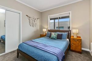 a bedroom with a blue bed and a window at The Landcastle ~Family Holiday Home~Corporate Wifi in Apollo Bay