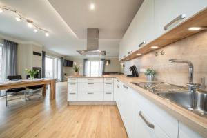 a large kitchen with white cabinets and a sink at Ferienhaus Seeblick - 78913 in Gammendorf