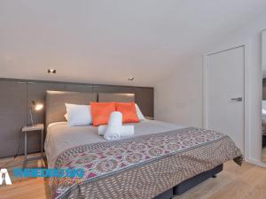 a bedroom with a large bed with orange pillows at Cedar Creek 3 in Thredbo