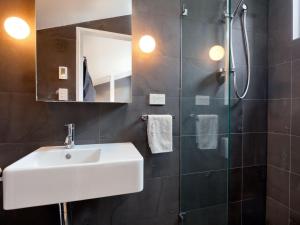 a bathroom with a white sink and a shower at Cedar Creek 3 in Thredbo