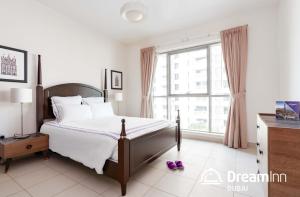 - une chambre avec un lit et une grande fenêtre dans l'établissement Dream Inn Apartments - Boulevard Central, à Dubaï