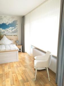 グレーミッツにあるHaus am Kurpark - Seewindのベッドルーム1室(ベッド1台、椅子、窓付)
