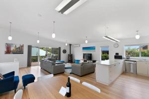 a large living room with a table and a kitchen at Charlie’s Beach House 1Block to Beach Pet Friendly in Apollo Bay